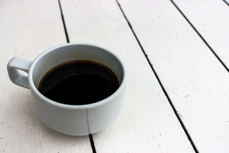 Cup of black coffee on white wooden table backgroundの写真素材
