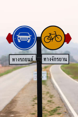 Pair of round traffic signboard with red arrow indicating: Car lane and Bicycle laneの写真素材
