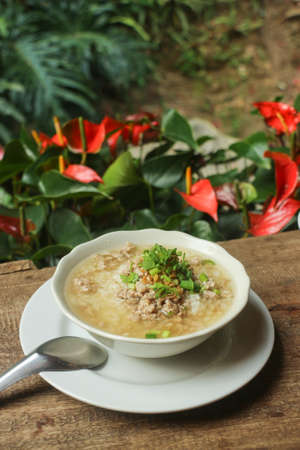 Boiled rice pork or mush on wooden table  - Thai style breakfastの写真素材