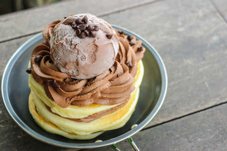 Stack of Homemade Pancakes with Chocolate Ice-Cream Scoops on Wooden Backgroundの写真素材