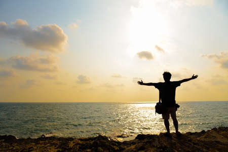 Shadow of man enjoy sunset over the sea, silhouette photo of manの写真素材