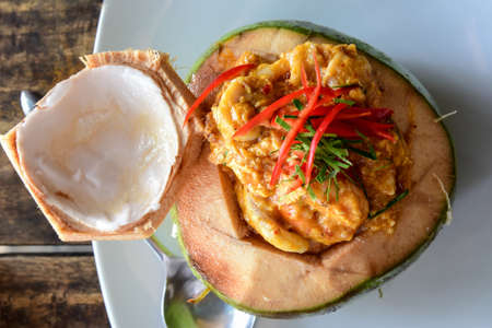 Top View of Curry Streamed Seafood in Coconut on wooden tableの写真素材