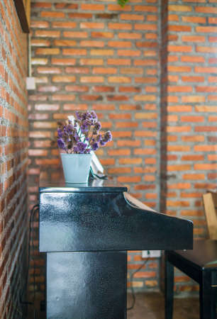 Side view piano. Blur red brick wall background.の写真素材