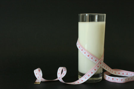 A glass of milk and body measuring tape