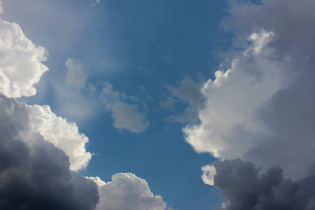 Blue sky with white and dark storm clouds
