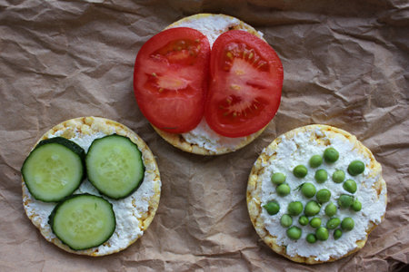 Round crispy corn sandwiches with vegetables toppings. Puffed corn cakes with cream cheese,...