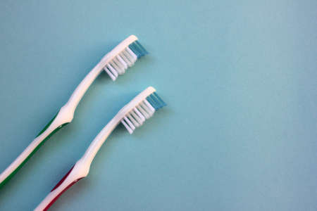Close-up of red and green toothbrushes on blue background with copy space. Top viewの写真素材