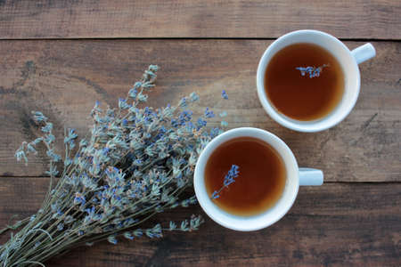 Cups of herbal tea with lavender flowers on wooden table from above. Healthy hot drink. Top view, copy spaceの写真素材