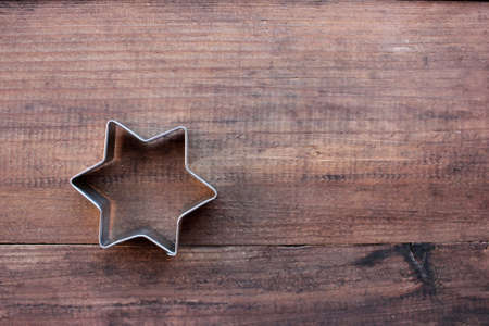 Christmas star shaped cookie cutters on a wooden table. Christmas background. Top view, copy spaceの写真素材