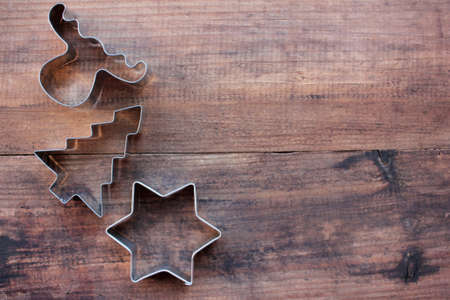 Christmas tree, star, and deer shaped cookie cutters on a wooden table. Christmas background. Top view, copy spaceの写真素材