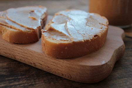 Close-up of Peanut butter sandwiches on wooden background. Slices of bread with peanut paste on a...