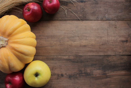 Autumn flat lay composition with pumpkins, and apples on a wooden table. Thanksgiving or Halloween...