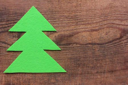 Christmas tree made of felt fabric on wooden background. Top view, copy spaceの写真素材