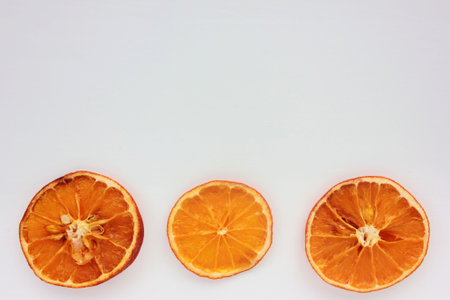 Dried oranges on white background. Flat lay Christmas border. Copy space