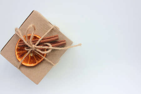 Craft Christmas gift box decorated with dried orange and cinnamon sticks. Zero waste echo-friendly present. Top view, copy spaceの写真素材