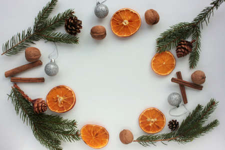 Christmas background with christmas decorations. Flat lay winter holiday composition with fir branches, walnuts, dried oranges, cones, and cinnamon sticks. Top view, copy spaceの写真素材