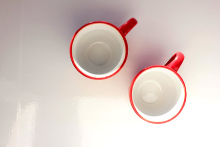 Couple of empty red espresso coffee cups on white table. Overhead view. Copy spaceの写真素材