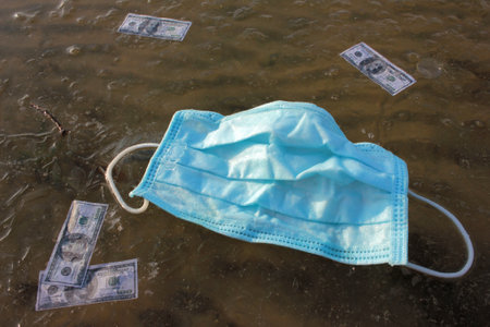 Blue protective mask and paper money on frozen river.の写真素材