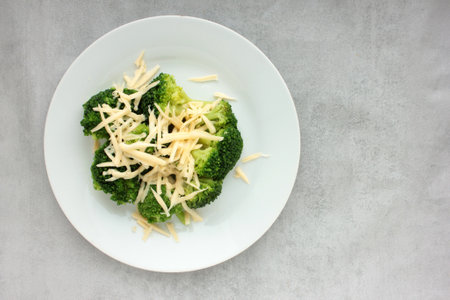 Broccoli with grated cheese on a plate. Healthy food. Overhead view. Close-upの写真素材