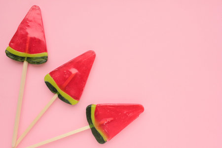 Watermelon ice creams on pink colored backdrop. Bright summer background. Lollipop in piece of...
