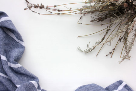 Dry lavender flowers and gray cloth napkin on white background. Floral frame. Flat lay composition,...