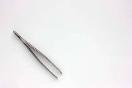 Eyebrow tweezer on a white background. Beauty and care concept. Top view, copy space.の写真素材