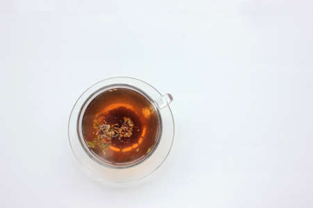 Cup of herbal oregano tea with dry marjoram flowers on white table background with copy space. Top view. Flat lay compositionの写真素材