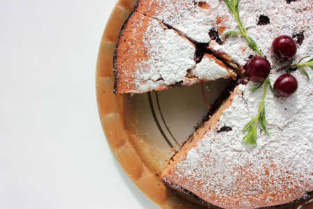 Pice of freshly baked cherry cake on white table background. Overhead view of homemade berry pie.の写真素材