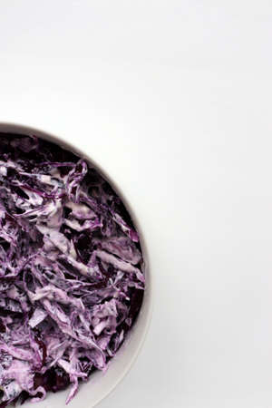 Easy homecooked creamy coleslaw from red cabbage in a bowl on white table background. Top view, copy space. Fresh vegetable salad with mayonnaise dressing. Flat lay food. Healthy eating conceptの写真素材