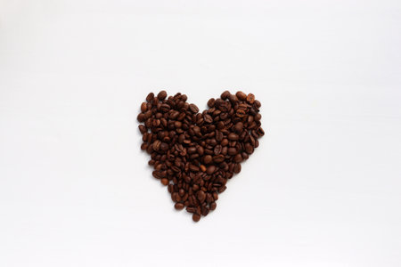 Heart shaped coffee beans on white table background. Top view, copy spaceの写真素材