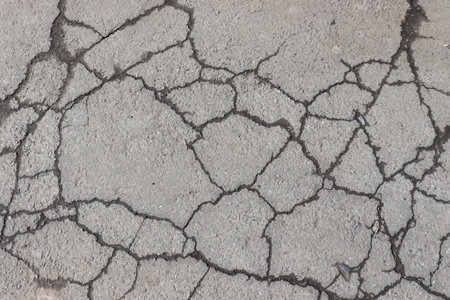 Cracked asphalt background. Old pavement texture with cracks.
