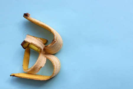 Banana skin on blue background. Using banana peel in compost or homemade fertilizer. Zero waste concept. Top view, copy spaceの写真素材