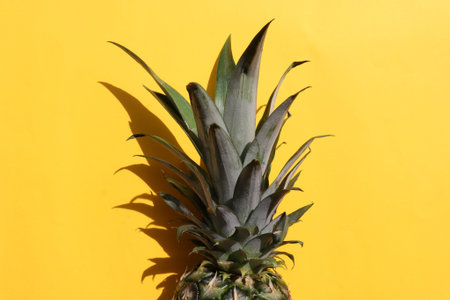 Pineapple on yellow background. Summer background with tropical exotic fruit. Top view, copy space....