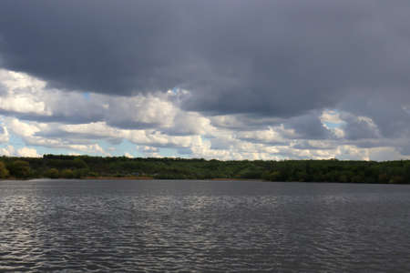 Stormy sky over the river. Rain clouds over the river.の写真素材