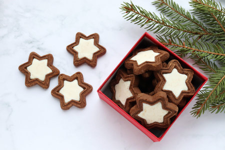 Christmas composition with star shaped cookies in red gift box, fir tree branches and christmas...