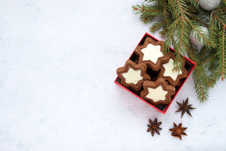 Christmas composition with star shaped cookies in red gift box, fir tree branches and christmas decorations on gray concrete background. Top viewの写真素材