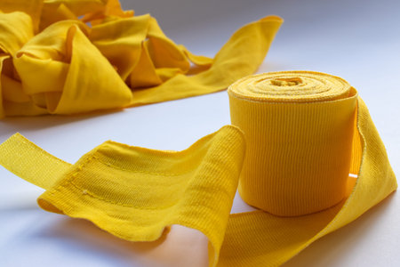 Yellow boxing hand bandage wraps on white background. Sports equipment for boxing. Top view, copy spaceの写真素材