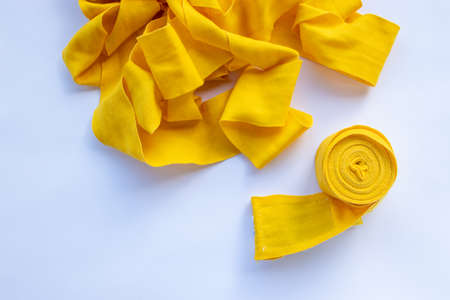 Yellow boxing hand bandage wraps on white background. Sports equipment for boxing. Top view, copy spaceの写真素材