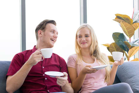 The couple is sat to drink coffee and discussed it in the morning, In a comfortable atmosphere By the window that has sunlight.の写真素材