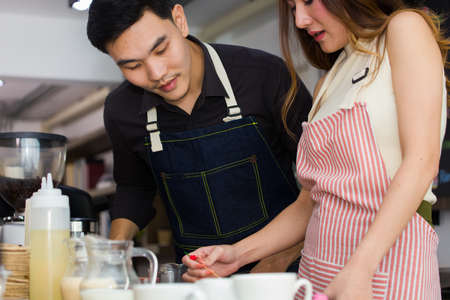 Young Asian people who dream of having a coffee shop is practicing to make coffee in a vocational training school.の写真素材