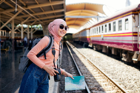 Female Islamic tourists hold cameras while waiting to travel.の写真素材