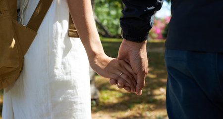 Close up of young couple walking hand in hand in the park.の写真素材