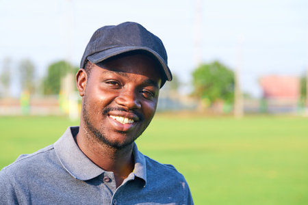 Black golfer wearing sport hat standing in an outdoor golf course.の写真素材