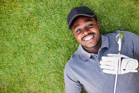 A black golfer lying on the green grass.の写真素材