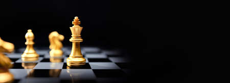 Concept of leadership. Golden king chess on the board on black background. Abstract images show business leadership with copy space.の写真素材