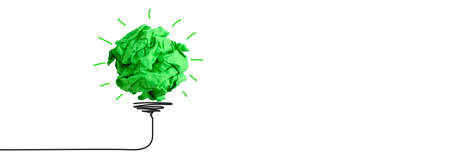 Concept of increasing the use of environmentally friendly clean energy. Crumpled lump of green paper like a light bulb on white background.の写真素材