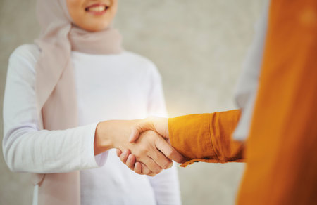 Muslim businesswomen shaking hands after concluding business negotiations.の写真素材