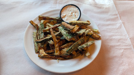 Fried zucchini with dipping sauce on the plate in Piraeus, Greeceの写真素材