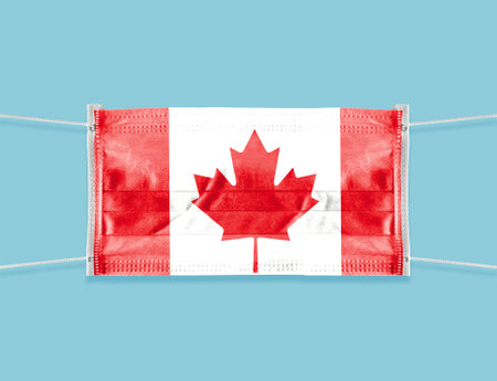 An individual face medical surgical mask with the flag of Canada on a blue background.の写真素材