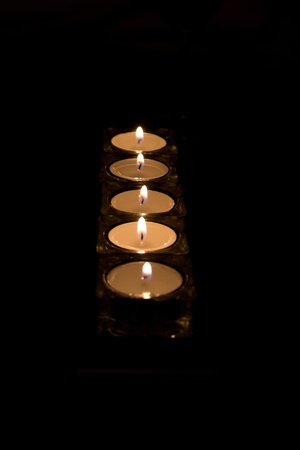 Tea light candles isolated on black の写真素材